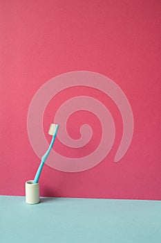 Toothbrush in holder on skyblue shelf. pink wall background