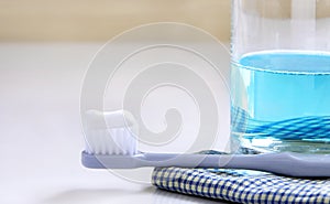 Toothbrush, mouthwash, and cloth on the white table.