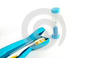 Toothbrush with a plastic case and dental Hourglass isolated on white background