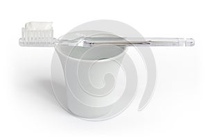 Toothbrush, toothpaste and a cup of water.