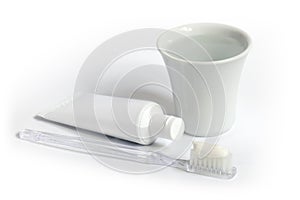 Toothbrush, toothpaste and a cup of water.