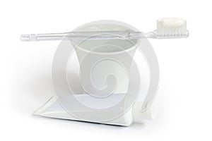 Toothbrush, toothpaste and a cup of water.