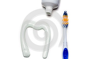 Toothbrush and toothpaste in the form of a tooth white background