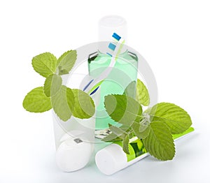 Toothbrush with toothpaste and fresh leaves of mint