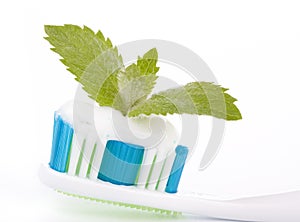 Toothbrush with toothpaste and fresh leaves of mint
