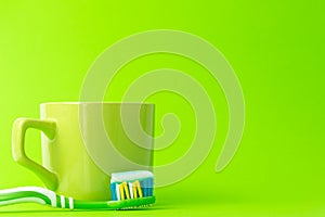 Toothbrush with toothpaste and green mug