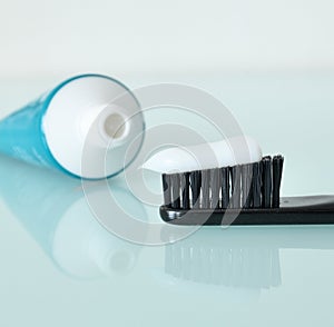 Toothbrush and toothpaste on a light blue background