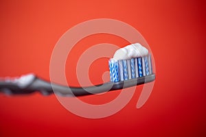 toothbrush with toothpaste on a red background