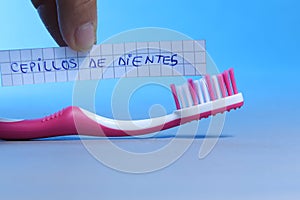 Toothbrush written on a small paper, cepillos de dientes in Spanish photo