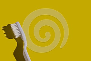 Toothbrush on the yellow background with space for text. Trendy stylish health care concept. Time to brush your teeth.