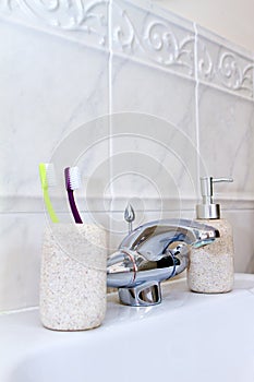 Toothbrushes in a clean white bathroom