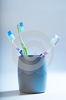 A toothbrushes in a cup on blue background