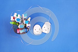 Toothbrushes and dental floss on blue background