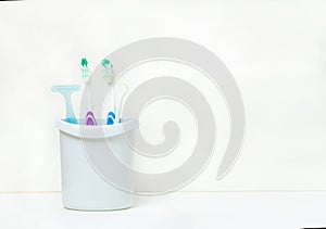 Toothbrushes and tooth accessory in white mug