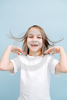 Toothless smiling 9 year old girl over blue background.