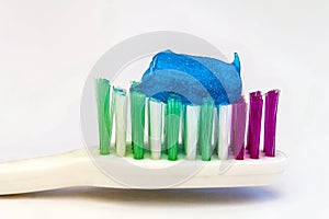Toothpaste on a toothbrush close-up on a white light background