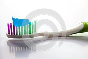 Toothpaste on a toothbrush close-up on a white light background