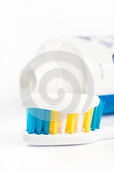 Toothpaste on toothbrush in closeup macro with toothpaste in the background