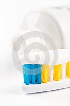 Toothpaste on toothbrush in closeup macro with toothpaste in the background