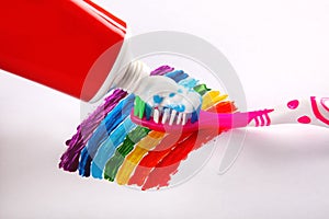 Toothpaste and toothbrush on rainbow background