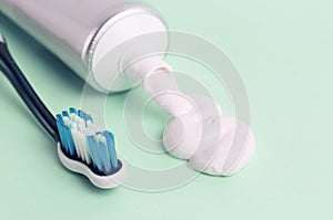 Toothpaste in tube and toothbrush on blue background. Dental hygiene concept