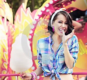 Toothy Smile. Young Woman with Cotton Candy in Amusement Park