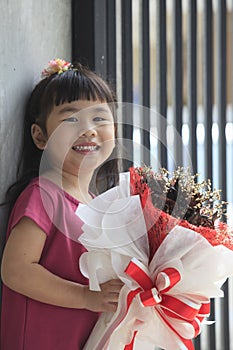 Toothy smiling face of asian kid happiness emotion and dry flowe