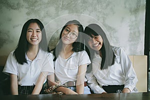 Toothy smiling face of asian teenager relaxing in home living room