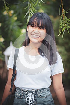 Toothy smiling face of asian teenager standing outdoor happiness emotion