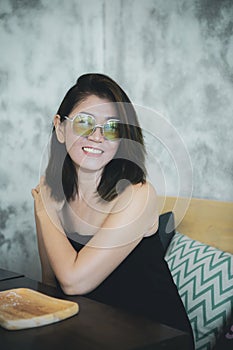 Toothy smiling face of asian woman relaxing in home living room