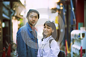 Toothy smiling face of asian younger man and woman in city life location