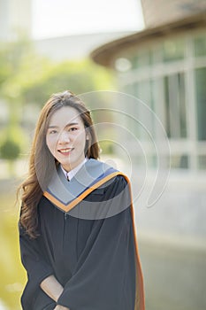 Toothy smiling face of beautiful asian younger woman wearing university graduated clothes happiness emotion