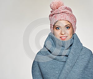 Toothy smiling woman portrait wearing winter scarf and hat.