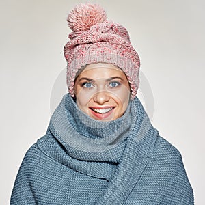 Toothy smiling woman portrait wearing winter scarf and hat.