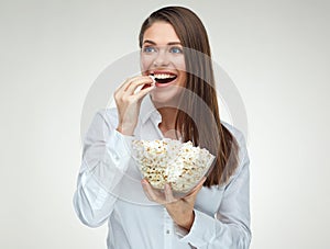 Toothy smiling young businesswoman eating pop corn.