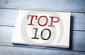 Top 10 sign on the white notepad on the blue wooden desk