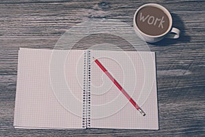 Top above close up view photo of Open notebook, pencil, cup of coffee with inscription `work` on it on grey wooden background, t