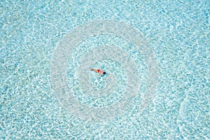 Top above high angle aerial drone view of pure blue clean clear ocean water pool girl diving exploring searching fish