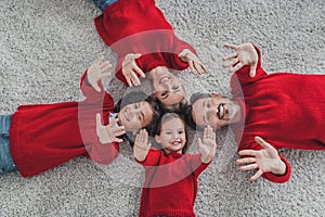 Top above high angle view of beautiful handsome cheerful family lying on carpet having fun December spirit at home