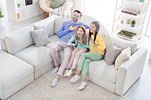 Top above high angle view full body photo of family happy positive smile sit sofa indoors laugh watch comedy remote
