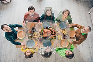 Top above high angle view portrait of adorable cheerful family holding hands eating homemade dish at home indoors photo