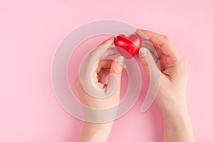 Top above overhead pov first person view photo of female hand holding a red heart isolated on pink pastel background with