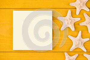 Top above overhead view close-up cropped photo of starfish and blank sticky notes isolated on yellow wooden background with