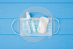 Top above overhead view close-up photo of sanitizer soap and mask isolated on blue wooden background with copyspace