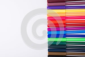 Top above overhead view photo of colorful markers with caps on placed to the right side isolated on white background