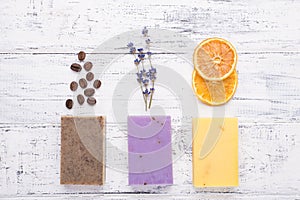 Top above overhead view photo of handmade organic soap bars with coffee beans lavender and dried orange slices isolated on white