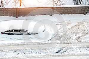 Top aerial view of apartment office building parking lot with many cars covered by snow stucked after heavy blizzard