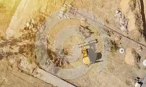 Top aerial view of big wheel loader excavator bulldozer work on a building project f