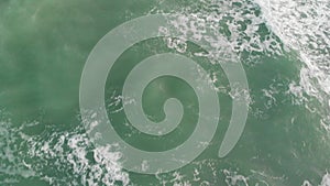 Top aerial view formation of a large ocean waves shows power of nature, the movement of emerald water generates white bubbling foa