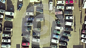 Top aerial view of many cars on a parking lot of supermarket or on sale car dealer market.